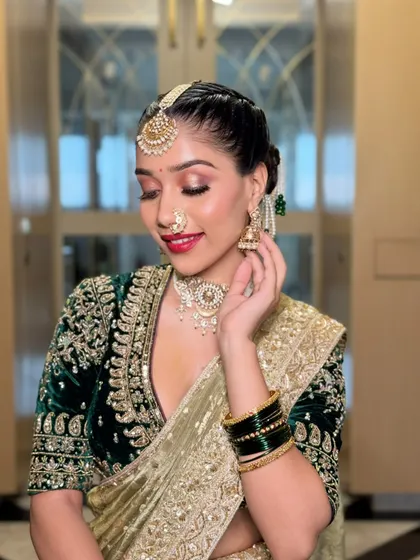 A graceful side profile, highlighting the elegant bun and the details of the jewelry. The makeup is polished and refined, completing this regal bridal look.