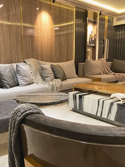 Here, we balanced dramatic elements with subtle textures. The oversized coffee table, crafted from a single block of Panda White marble, anchors the room, while the fluted and wood grain wall panels add warmth and depth.