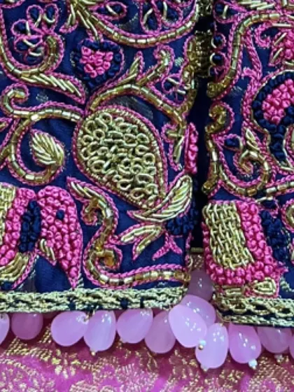 A full view of the sleeve hem with the beautiful pearl tassels. These small details complete the overall look of the custom blouse.