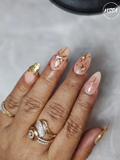 A collection of various nail art samples, from celestial and gold-leaf designs to embossed sweater patterns and fruit art, all showcasing the diverse skills our students learn at the academy.