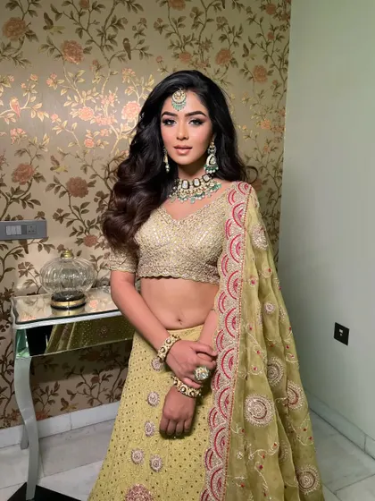 A fresh and glamorous look for a pre-wedding event. This lime green Faabiiana lehenga is styled with contrasting turquoise jewelry, creating a vibrant and youthful feel perfect for a Mehendi or Sangeet.
