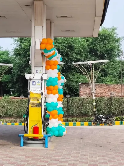 A spiral balloon garland wrapped around a pillar at a petrol station. This is a simple yet effective way to add a festive touch to commercial forecourts.