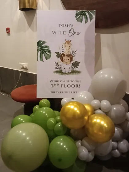 A personalized welcome sign is a great way to guide guests. This one for the 'Wild One' party matches the jungle theme and directs guests to the celebration area.