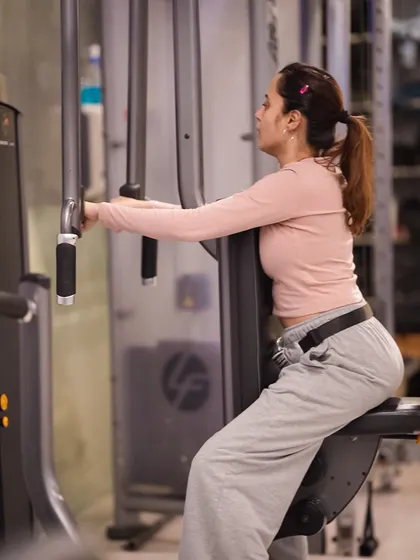 The pec deck machine is great for isolating the chest muscles. This client maintains focus and control through each repetition.