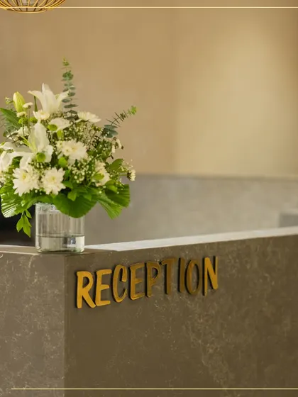 The reception desk at my Ahmedabad store, adorned with fresh flowers. Every detail is designed to create a warm and luxurious welcome for my clients.
