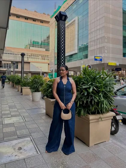 The dark wash of this denim jumpsuit is flattering and versatile, easily dressed up or down. Here, I've paired it with a simple nude bag.
