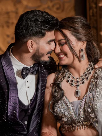 An intimate and romantic close-up of the couple. This shot highlights the bride's flawless makeup, sparkling diamond and sapphire jewelry, and the genuine happiness shared between them.