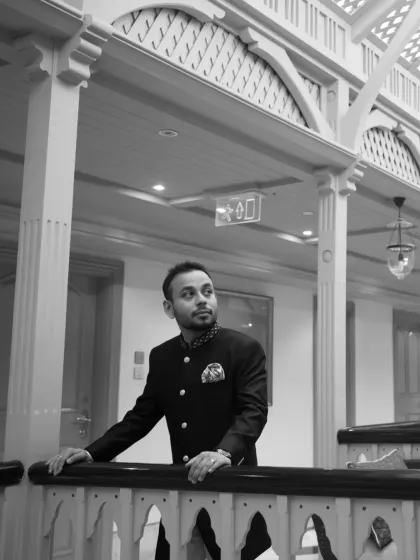 A handsome black and white portrait of the groom, looking thoughtful and elegant in his wedding attire. This shot captures a quiet moment of reflection.