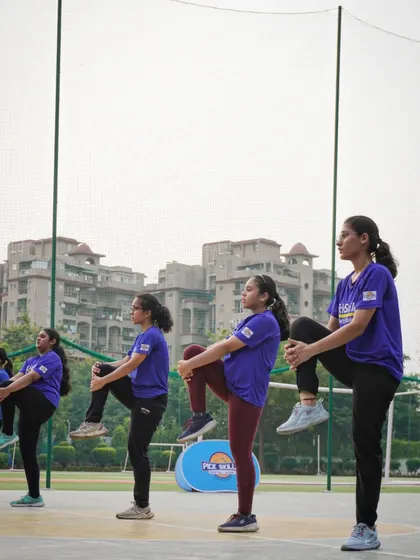 A group of our female athletes performing dynamic stretches during a warm-up. Flexibility and proper preparation are key components of our training, helping to maximize performance and prevent injuries.