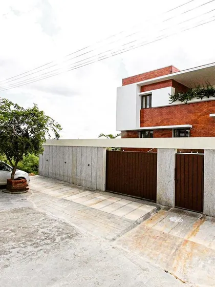 The MV Residence in Banashankari, a contemporary home characterized by its clean white forms, exposed brick sections, and a strong connection to its site.
