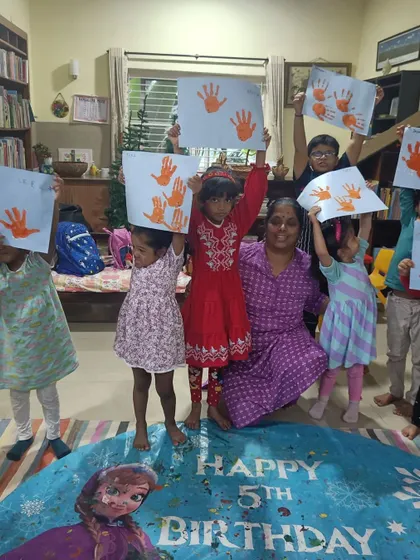Another shot of the children proudly displaying their handprint art.