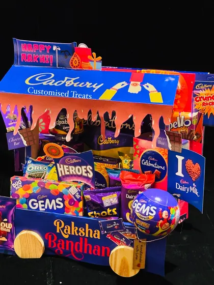 This Cadbury-themed Rakhi hamper is a chocolate lover's dream. Shaped like a delivery truck, it's overflowing with a variety of Cadbury chocolates, from Dairy Milk to Gems, perfect for a sweet-toothed sibling.
