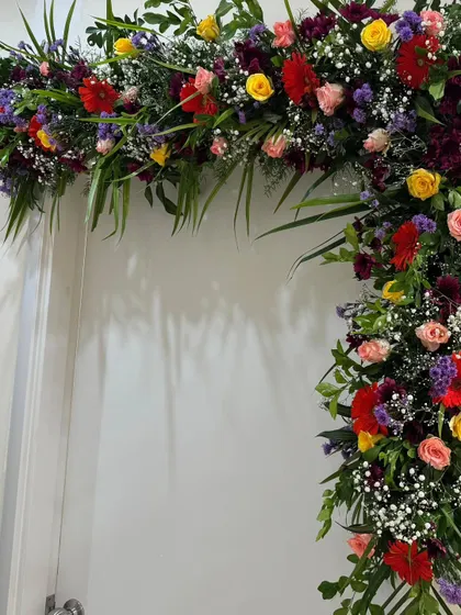 This image shows the detail of a floral door arch. I combine different flowers like roses and gerberas with various types of leaves to create a full and multi-dimensional arrangement.