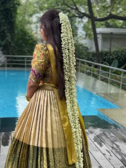 Another angle of the long jasmine flower braid, showing how it flows beautifully against the golden lehenga. This is a perfect example of a statement bridal look.