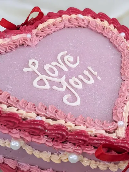 A close-up on the hand-piped "Love You!" script. We take care to make every detail perfect on our romantic vintage cakes.