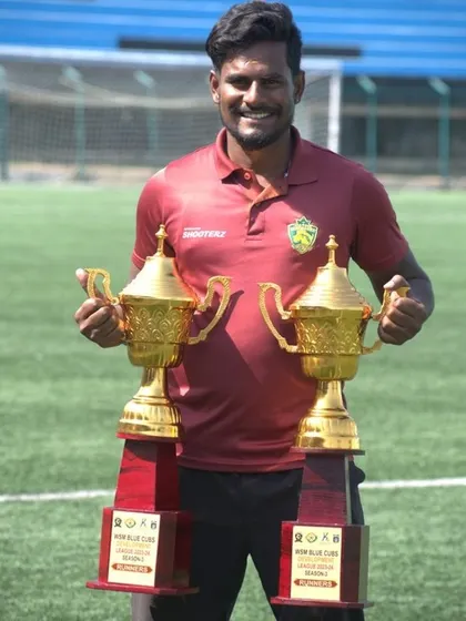 One of our senior coaches holding the Runners Up trophies from the WSM Blue Club League, representing our academy's consistent success.