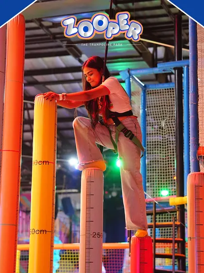 An adult tackles the pillar climbing challenge. It's a great way for team members to push their limits and cheer each other on.