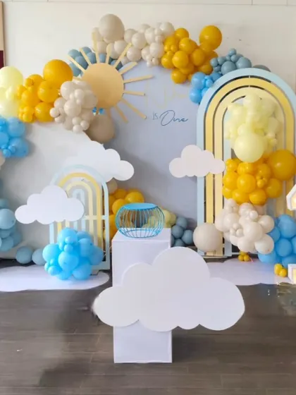 A sweet "You are my sunshine" theme for a first birthday, with sun and cloud cutouts and a cheerful yellow and blue color palette.