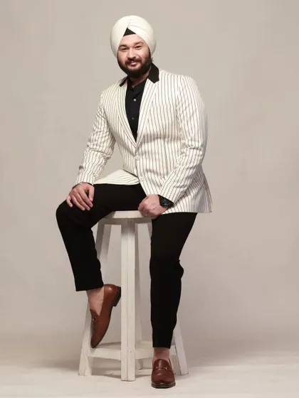 Sustainable fashion is the future. A model looking stylish in our white pinstripe blazer with a black shawl collar, paired with black trousers.