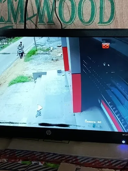 This camera monitors the entrance of a shop with its shutter partially down.