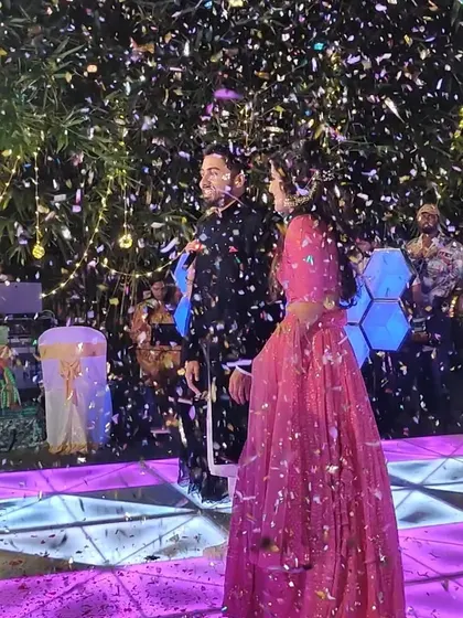 A couple stands on stage under a shower of confetti. We love creating these picture-perfect, celebratory moments for our clients.