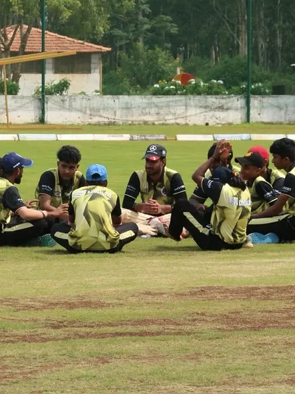 A team discussion on the field, where players and coaches strategize and motivate each other during a break.