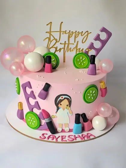 A spa party theme cake for Sayesha's birthday. The cake is decorated with nail polish, lipstick, cucumber slices, and other spa day essentials.