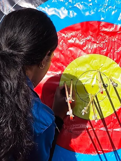 A female archer scoring her arrows. Precision and attention to detail are skills we nurture in all our students.
