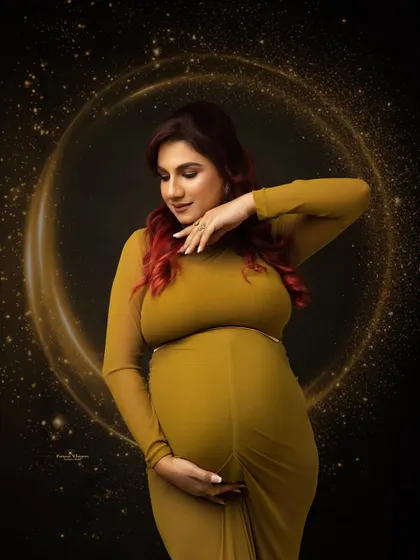 A fine art portrait with a touch of sparkle. A golden light effect encircles the mother-to-be, adding a magical and celebratory feel to the image.