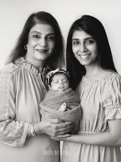 A beautiful composition with the grandmother and mother holding the newest family member.