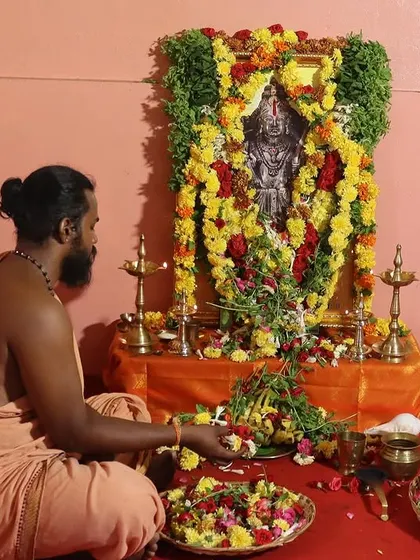 Seated before the altar, I prepare flower offerings for the puja. Each element of the ceremony is performed with mindfulness and deep reverence for the tradition.