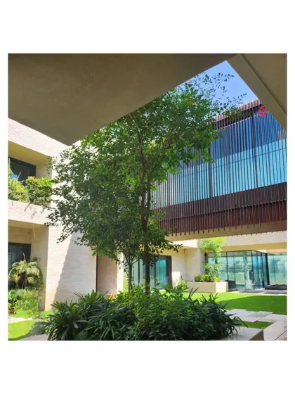 A view of the corten steel bridge traversing the courtyard of our Dubai Hills villa. The design creates a dynamic connection between the two wings of the house, framed by lush greenery.