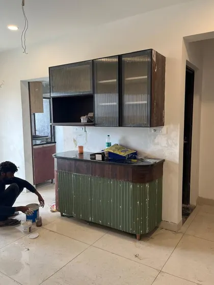 Getting the final details right on a fluted green bar cabinet. Our team works meticulously on-site to ensure every piece is installed to perfection.
