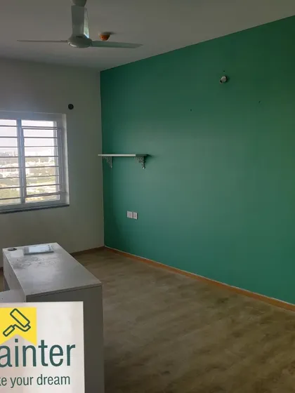 A room with a teal-green accent wall, creating a calm yet colorful environment. The small shelf shows how functional items can be added after painting.