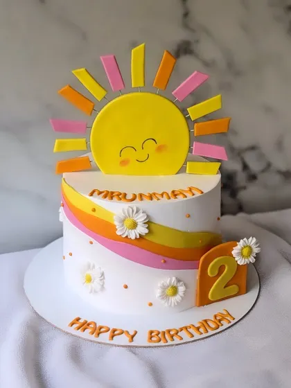 You are my sunshine! A bright and happy cake for a 2nd birthday, featuring a smiling sun, a colorful rainbow wave, and cute daisies.