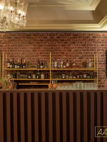 The bar was the heart of our speakeasy. I designed it with a rustic brick backdrop, industrial-style shelving, and quirky portraits of animals in masquerade masks to complete the vintage, clandestine vibe.