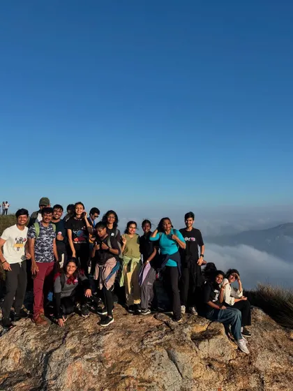 A group of college students celebrating their successful climb to the summit, high above the clouds. The sense of accomplishment is a powerful part of our leadership treks.