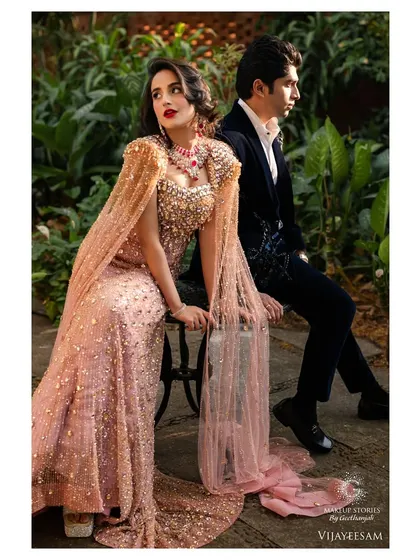 A full length shot of the couple, exuding elegance and style. The makeup is a key part of the overall high fashion aesthetic of this "Timeless Hollywood Glamour" shoot.