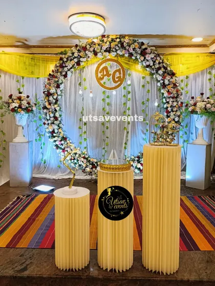 An elegant engagement stage centered around a large ring made of fresh flowers. The custom gold monogram inside the ring adds a personalized touch for the couple.