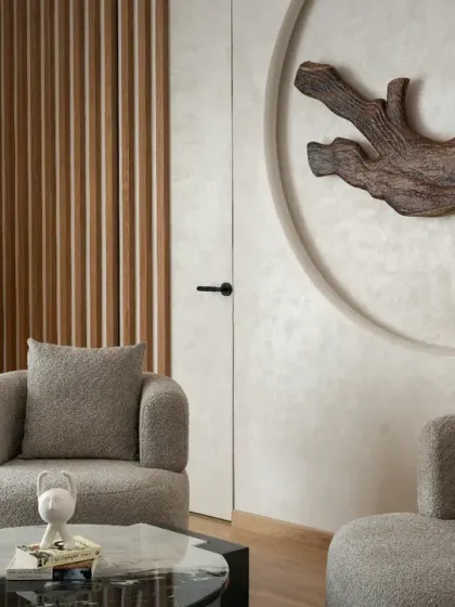 The son's bedroom in The House of Dancing Screens uses an earthy color scheme. Soft curves, textured furnishings, and a custom wooden art piece give this room a sophisticated and personal charm.