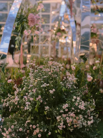 A close-up of the dreamy fresh florals used in the mirrored arch mandap. The soft textures and colors of the baby's breath and other wildflowers created a delicate contrast with the modern structure.