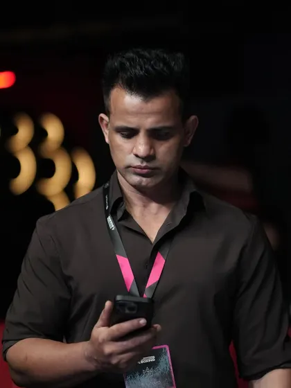 The work never stops. A shot of our founder focused on his phone, managing the countless details that go into building a successful promotion.