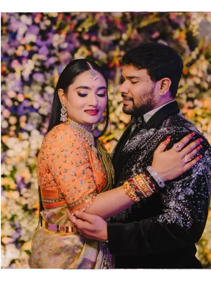 An intimate embrace between the couple on their reception stage. The bride's contentment and the groom's affection are beautifully captured.