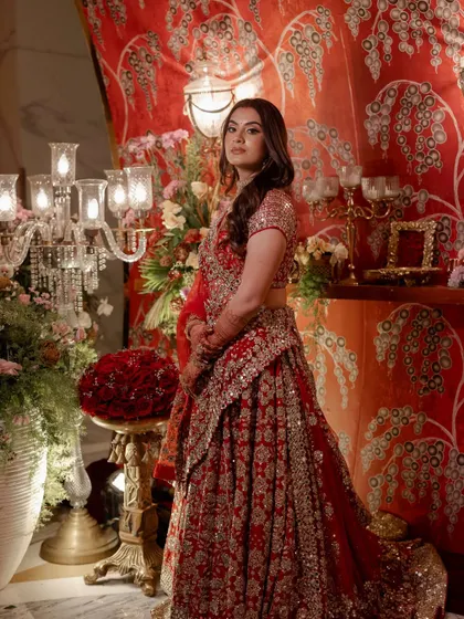 The beautiful bride posing against the custom-printed fabric wall at the entrance of her reception.