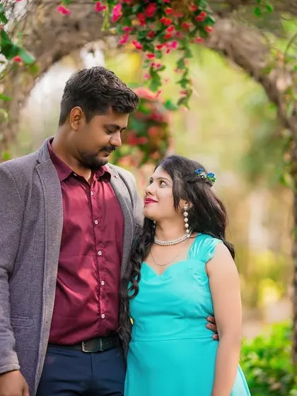 A sweet and simple portrait of a couple standing together under a floral arch.