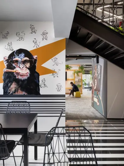 This view shows the 'Smokin Monkey' mural in the context of the office's cafeteria and seating area, highlighting the black and white striped theme.