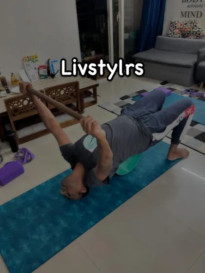 Another client using a yoga wheel and stick for a supported bridge pose, demonstrating a focus on spinal mobility and strength.