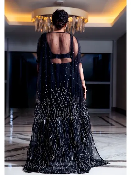 The back of the black saree-gown features a sheer cape, adding an element of drama and elegance.