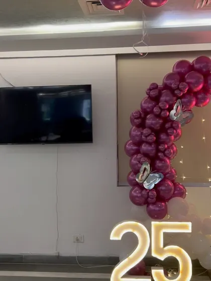 A partial view of the 25th anniversary setup, showing the marquee numbers and a portion of the balloon arch.