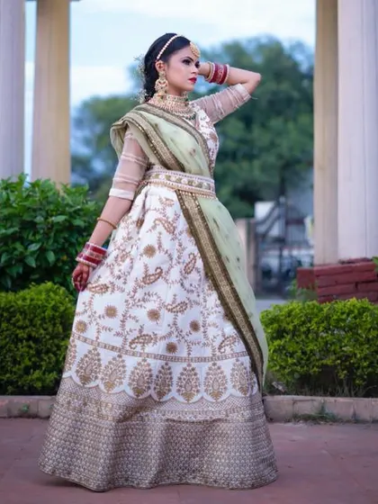 A full view of the white and gold embroidered lehenga. This rental outfit is perfect for brides looking for a non-traditional color that is still incredibly elegant and bridal.
